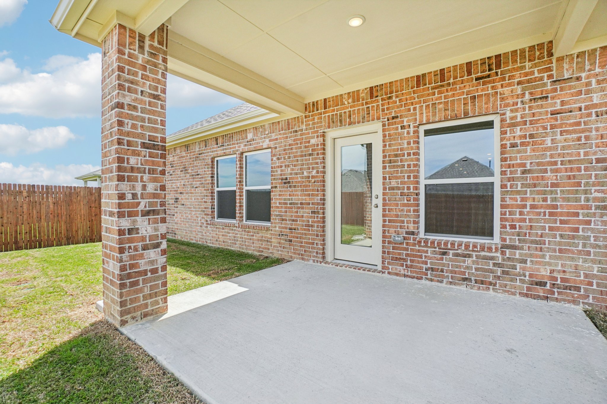 A brick building with a white tile patio.