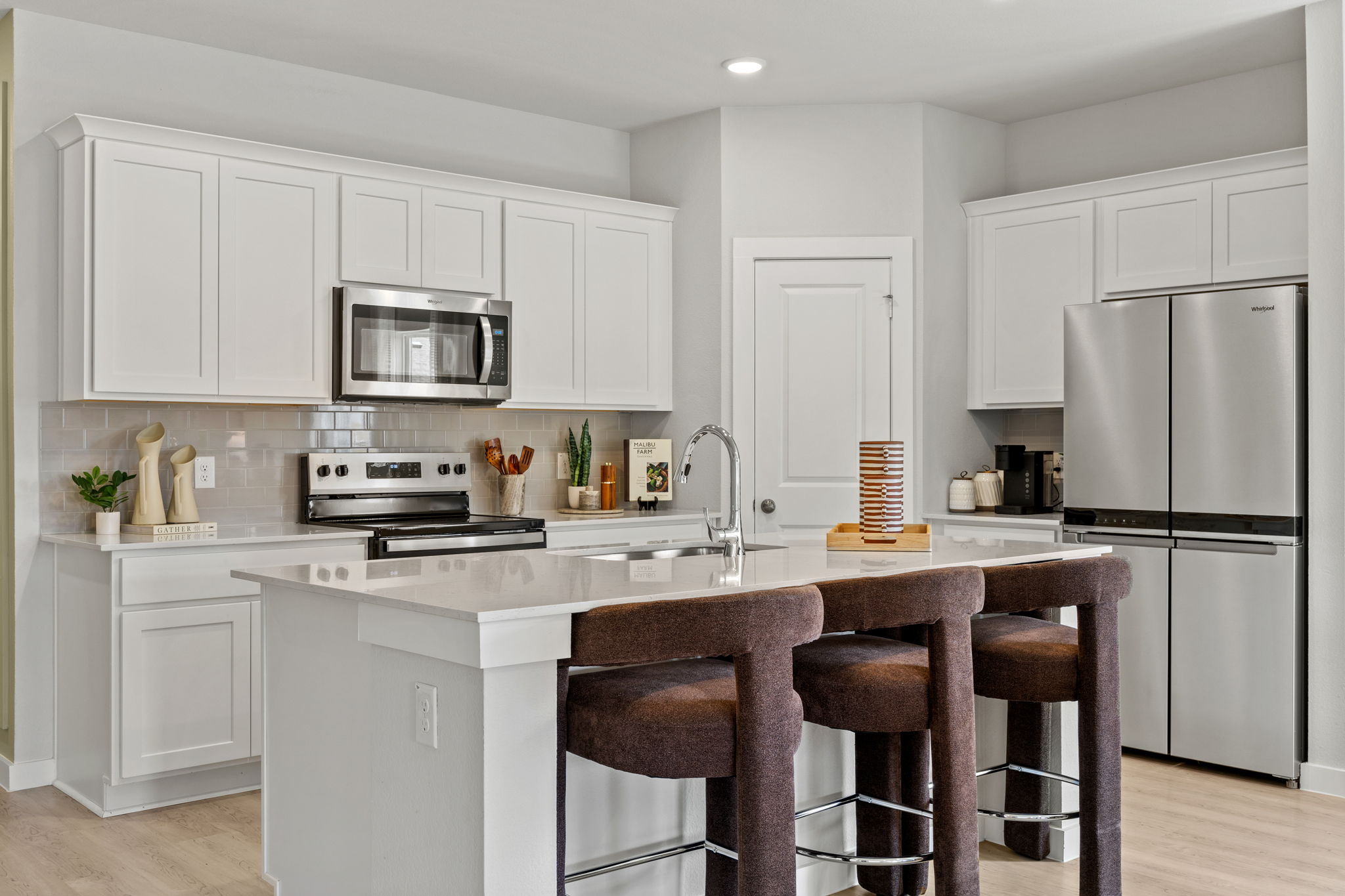 A kitchen with white cabinets.