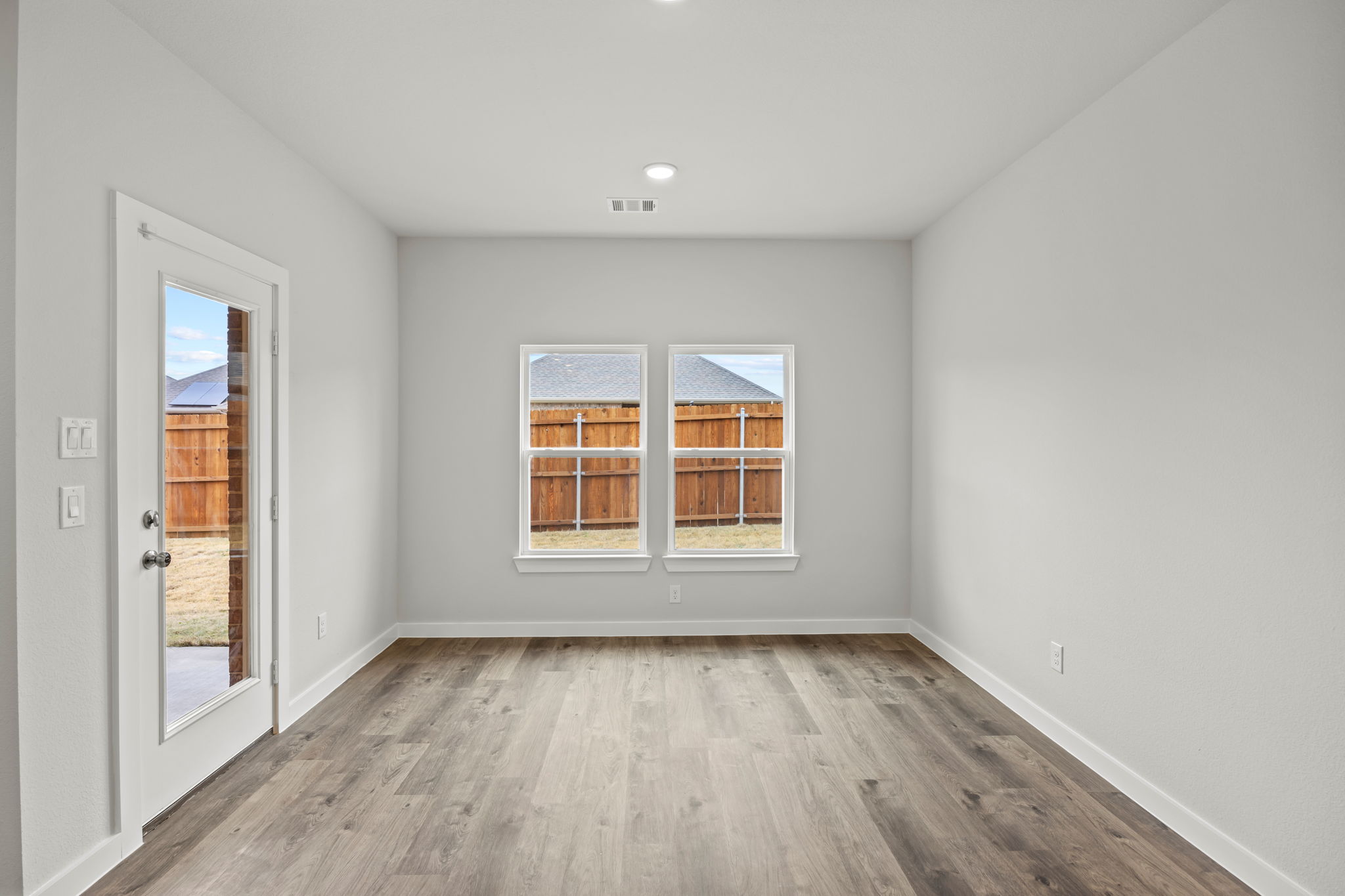 A room with a wood floor and a window with a wood floor.