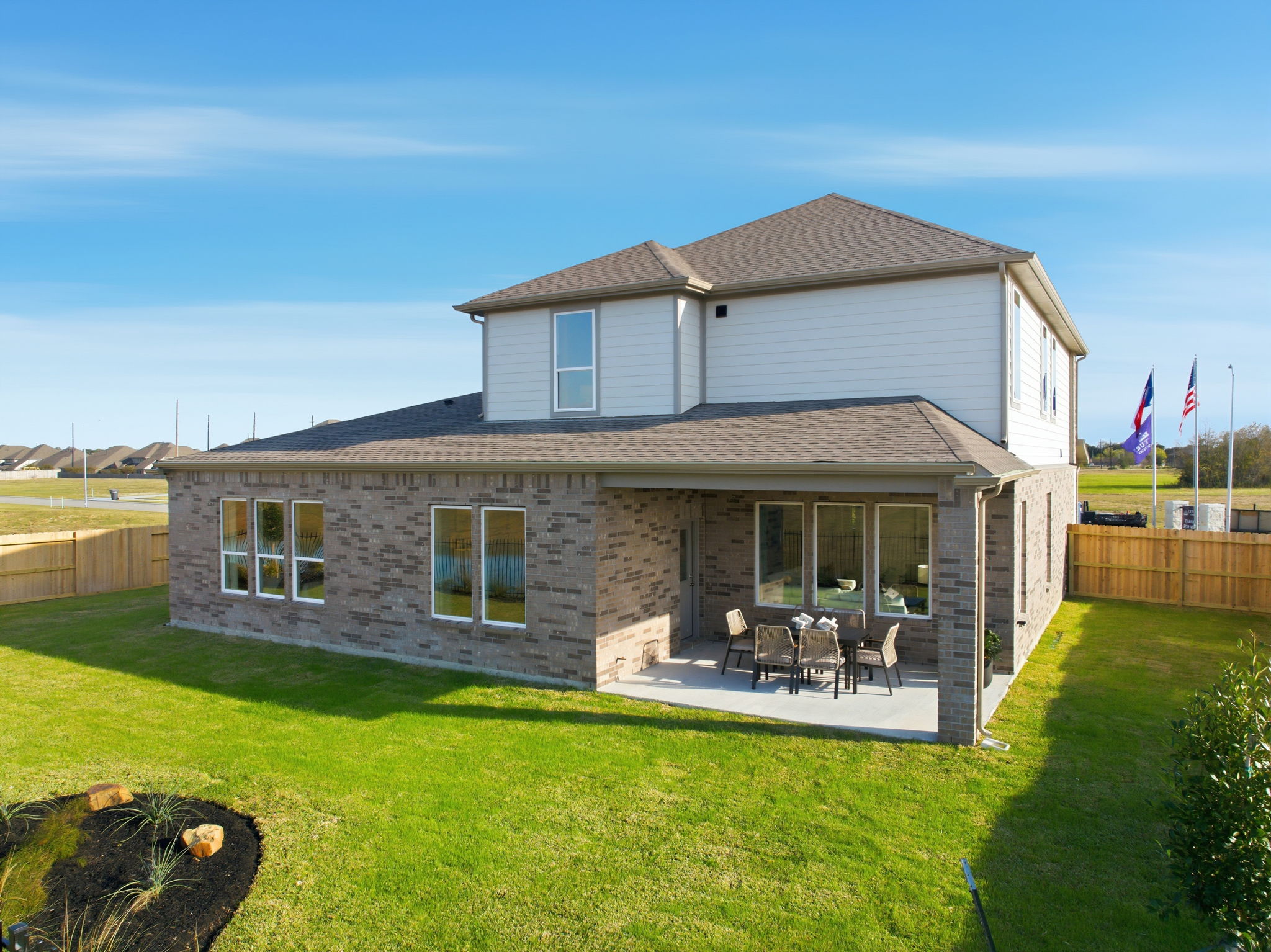 A house with a lawn and a table and chairs in the front.