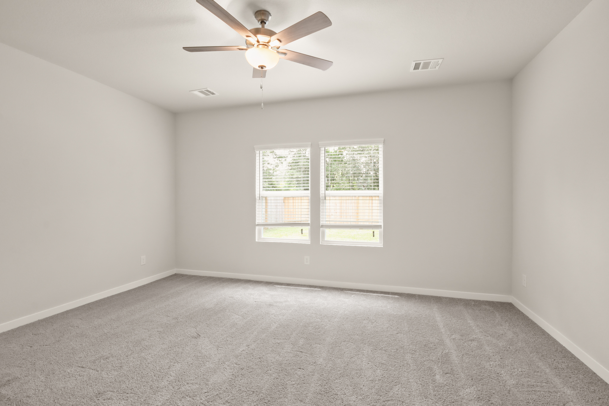 A room with a ceiling fan and a window.