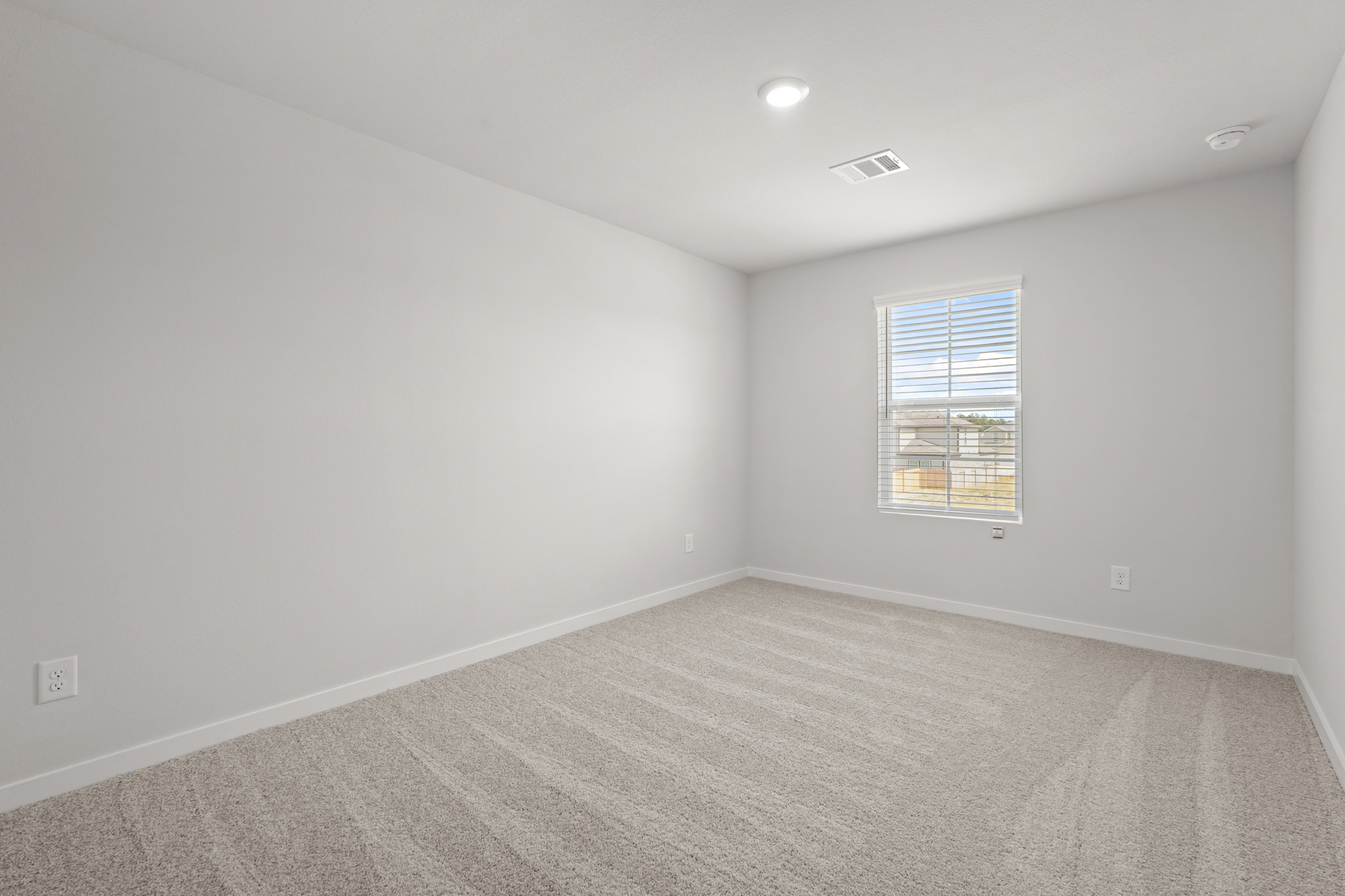 A room with a window and a carpet.