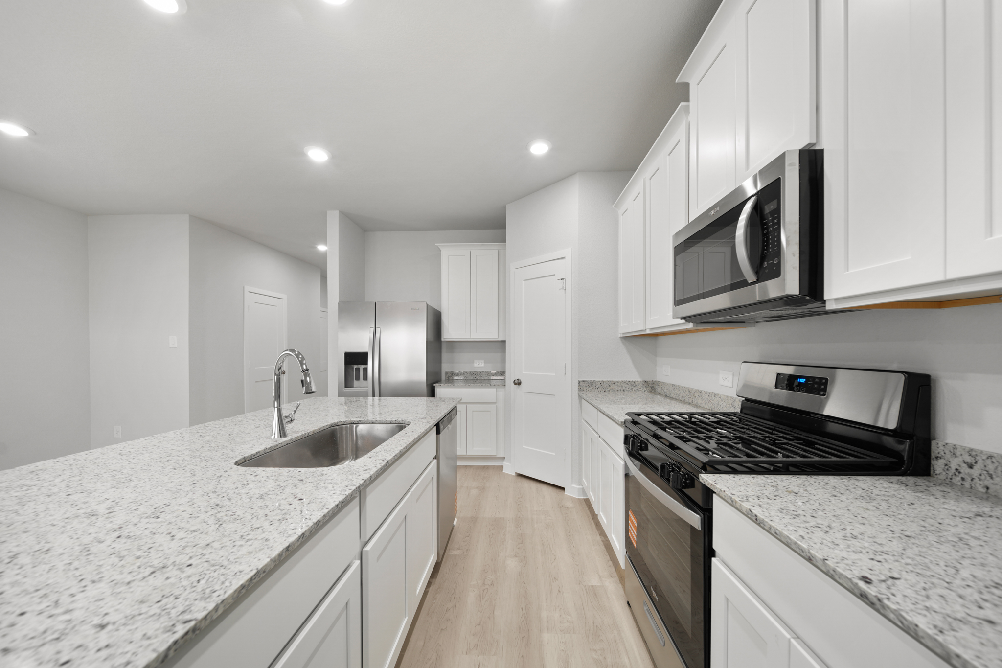 A kitchen with white cabinets.