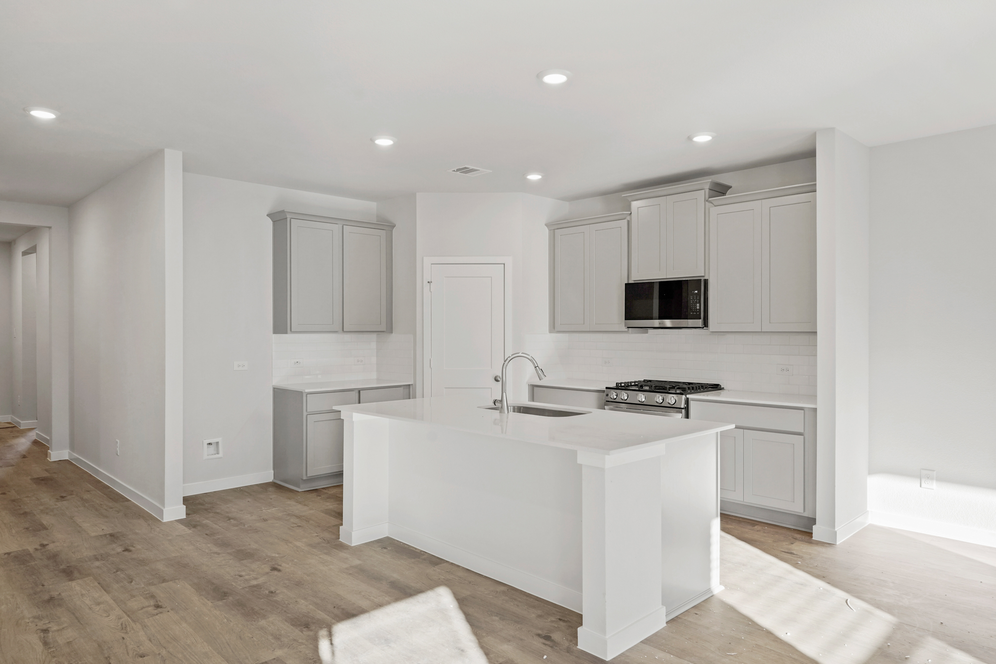 A kitchen with white cabinets.