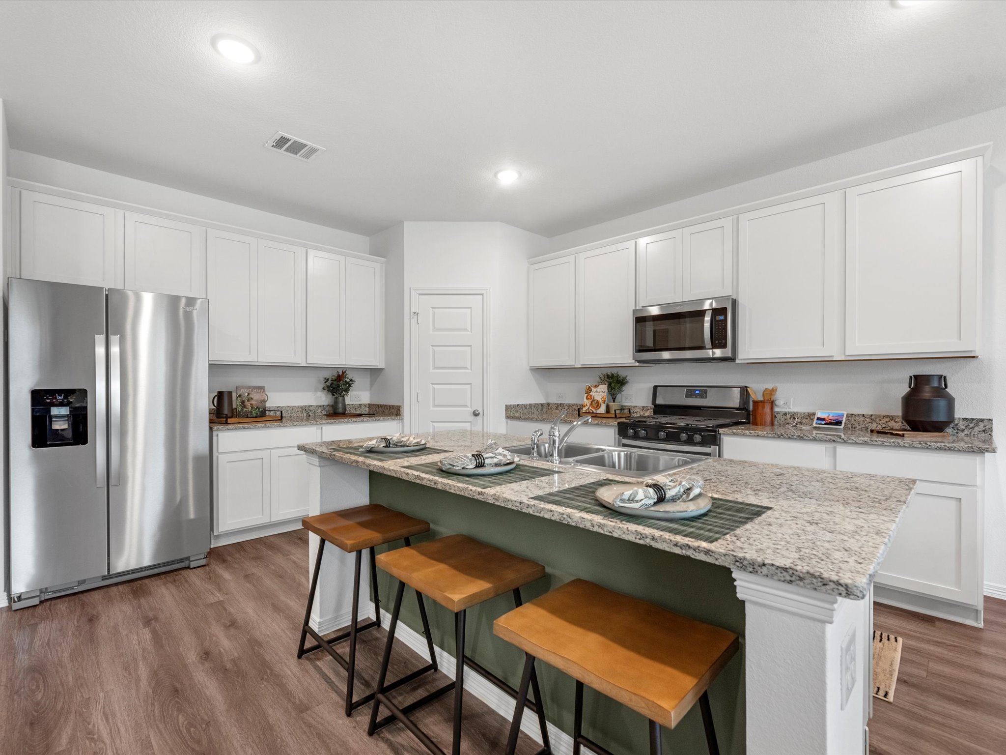 A kitchen with white cabinets.