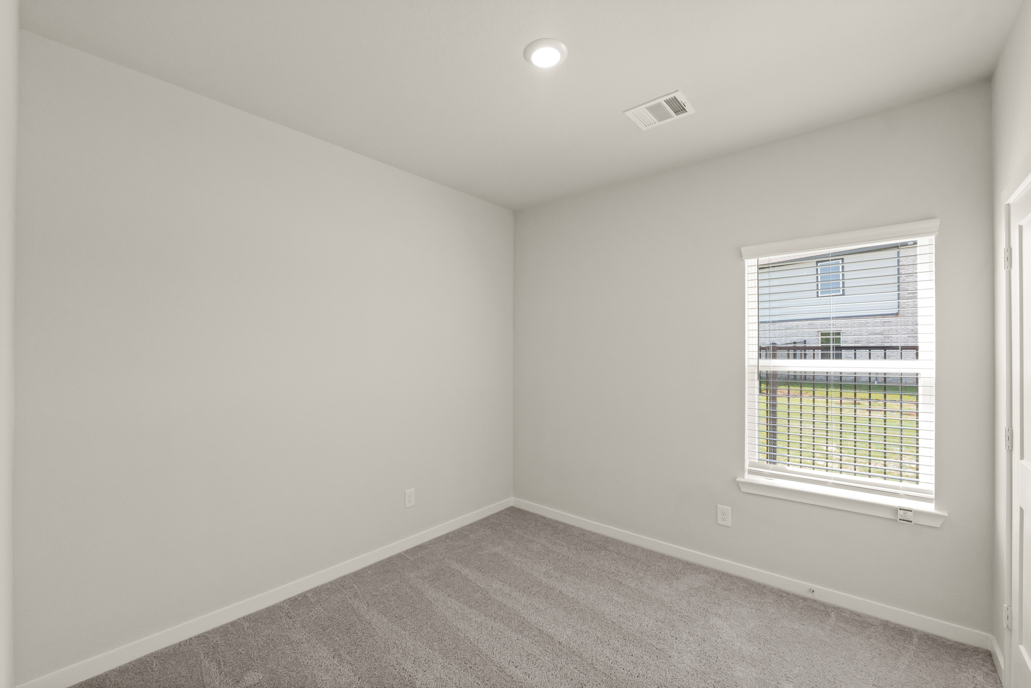 A room with a window and a carpet.