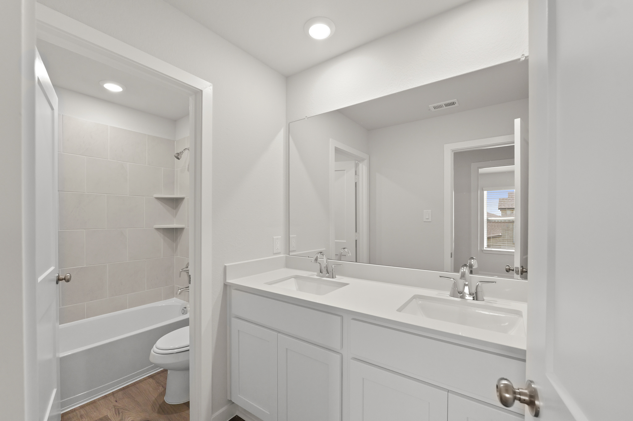 A bathroom with a sink toilet and mirror.