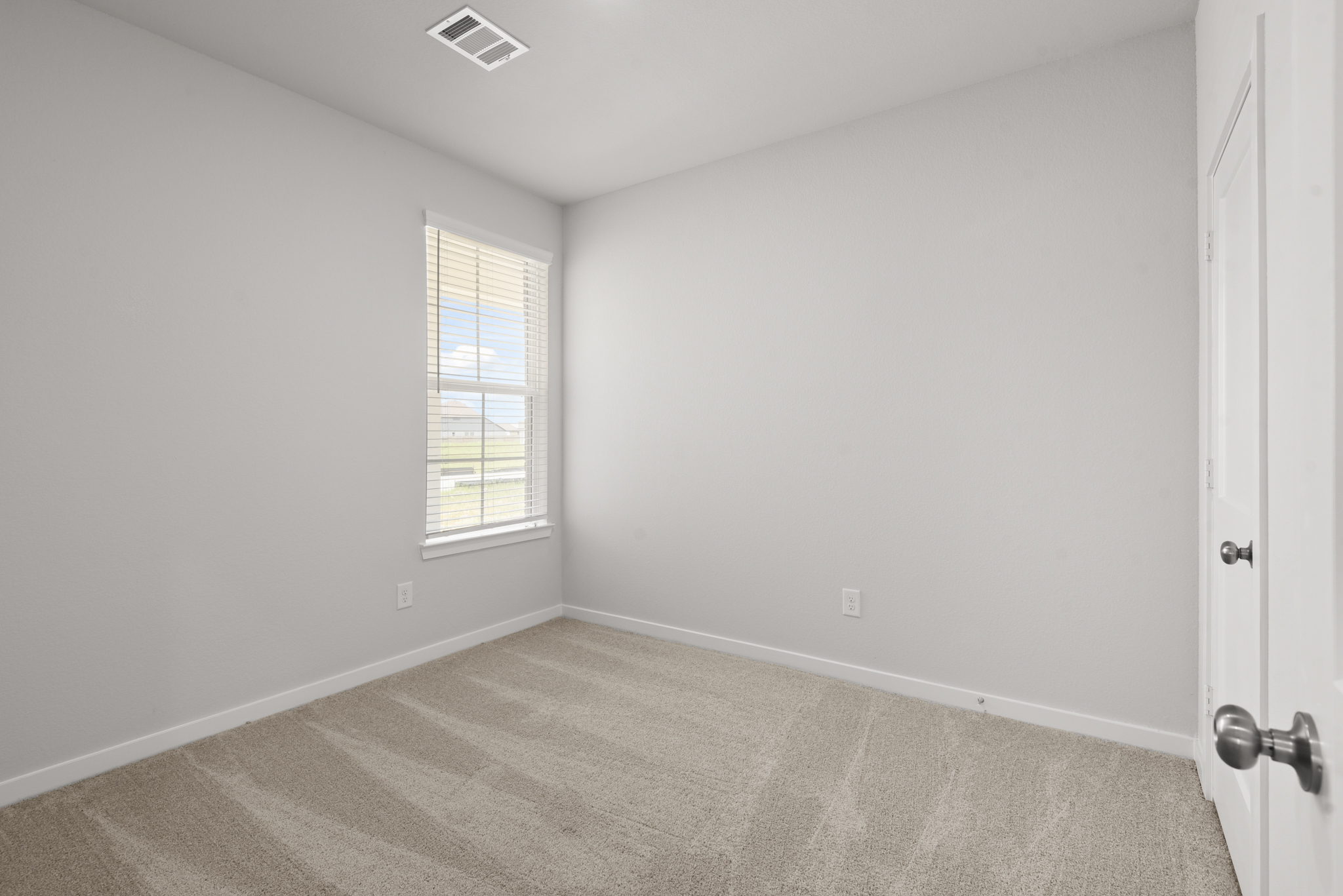 A room with a window and carpet.