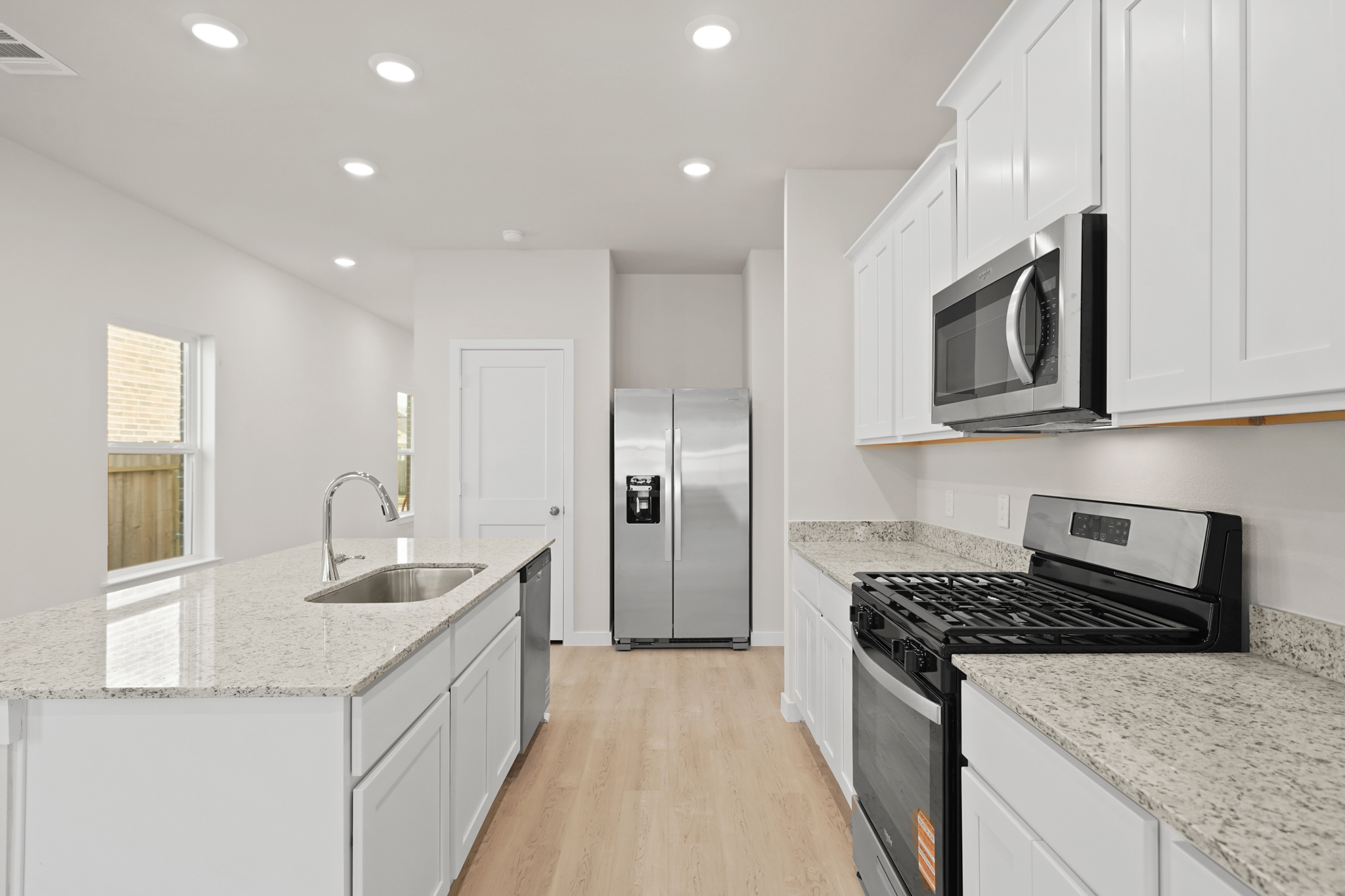 A kitchen with white cabinets.