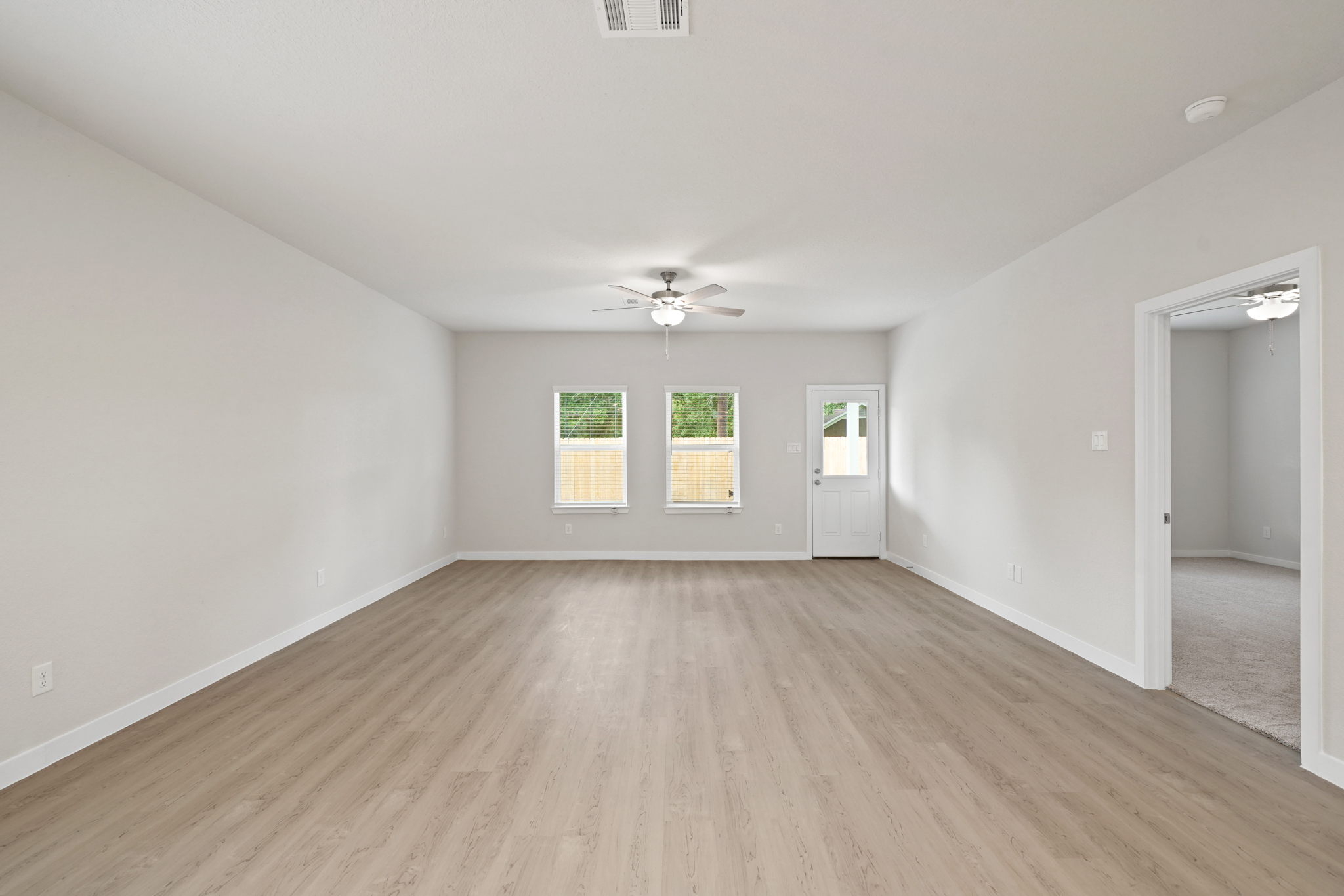 A room with a wood floor and a ceiling fan.