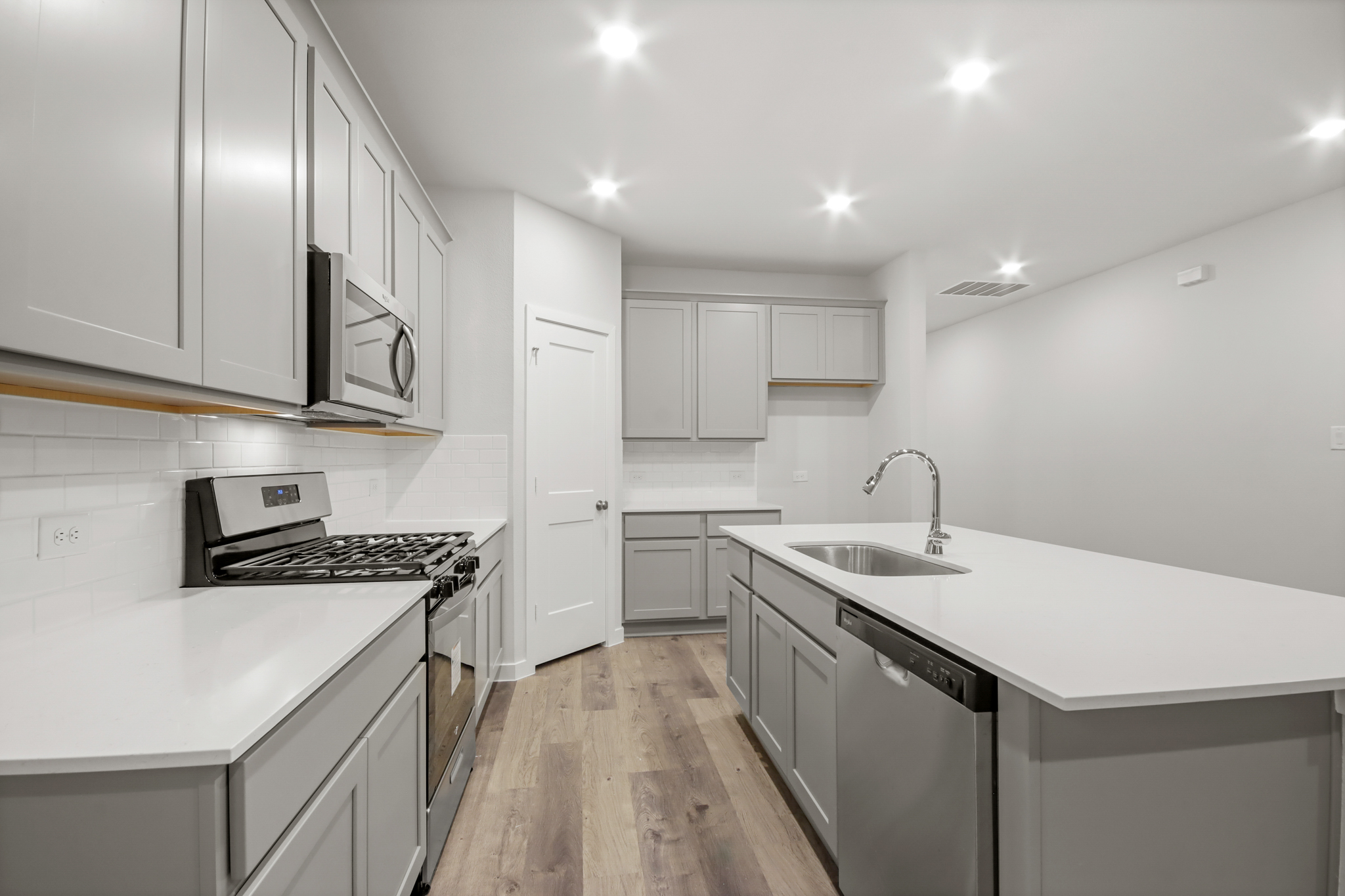 A kitchen with white cabinets.