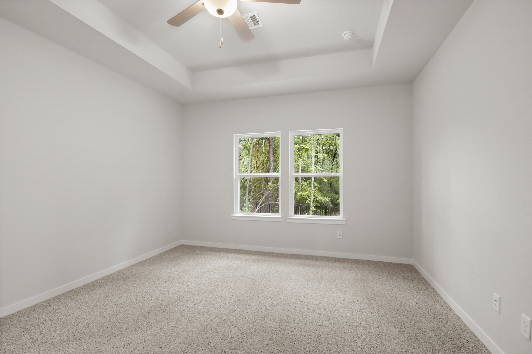 A room with a ceiling fan and a window.