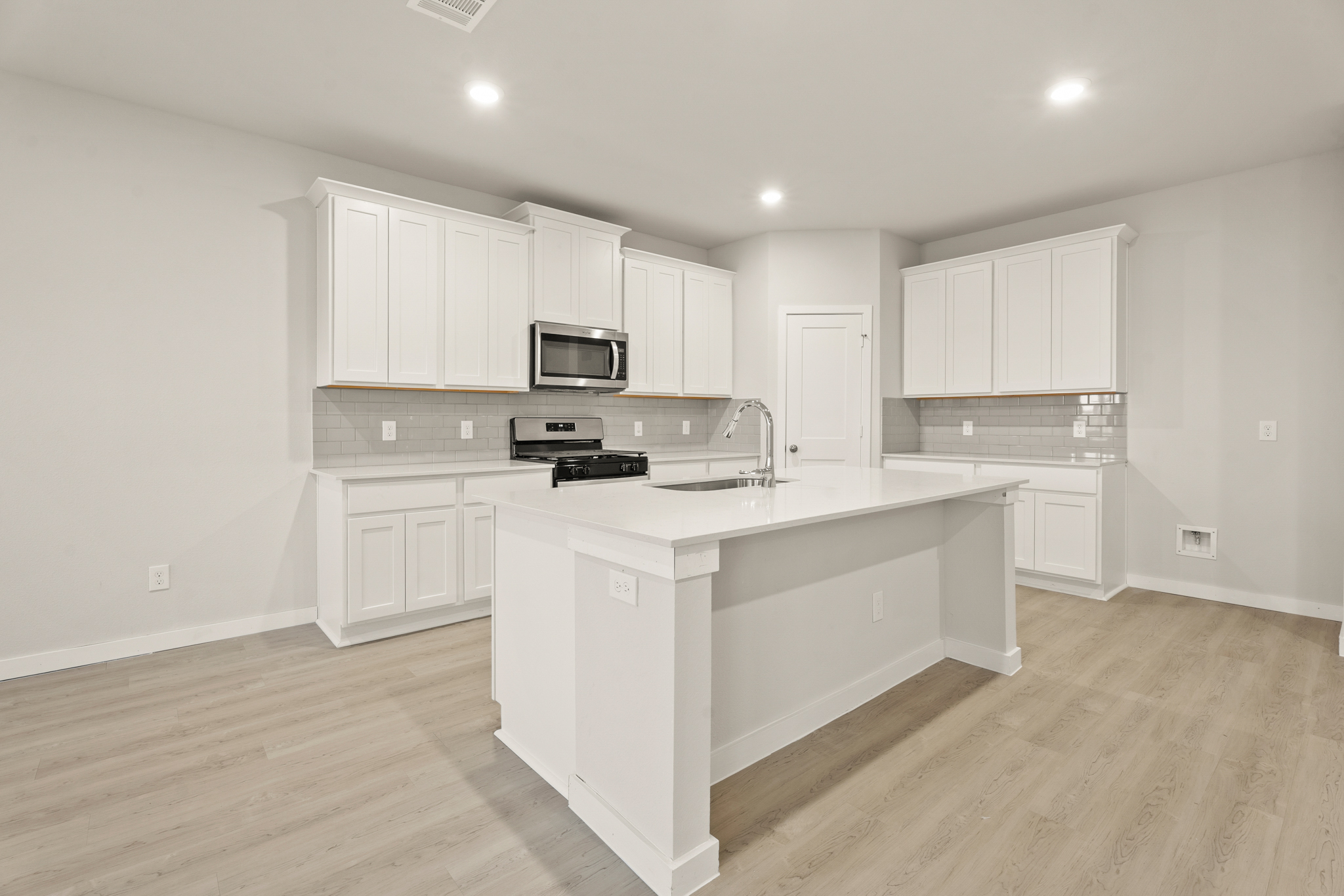 A kitchen with white cabinets.
