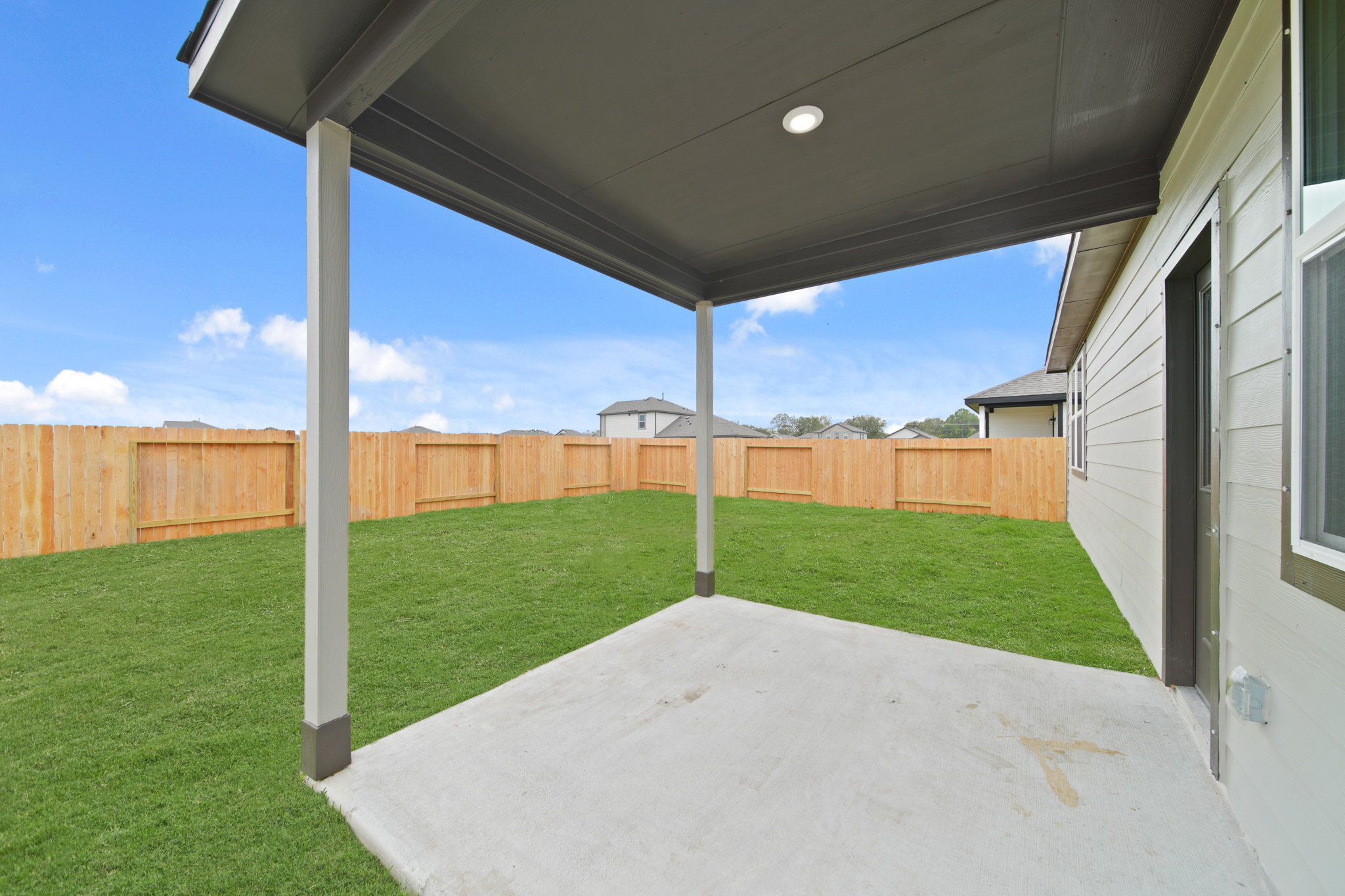A backyard with a fence and a metal structure.