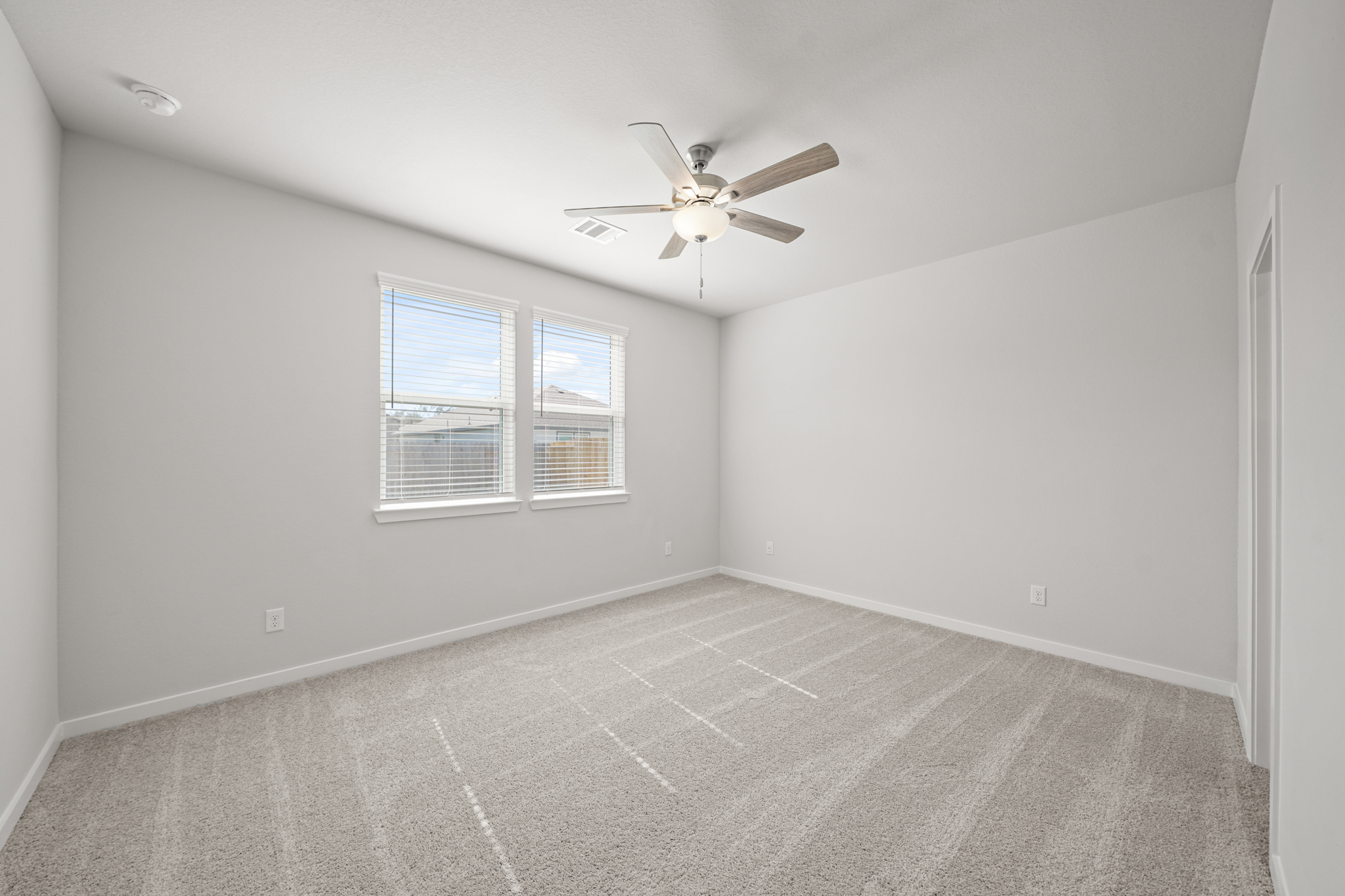 A room with a ceiling fan and a window.