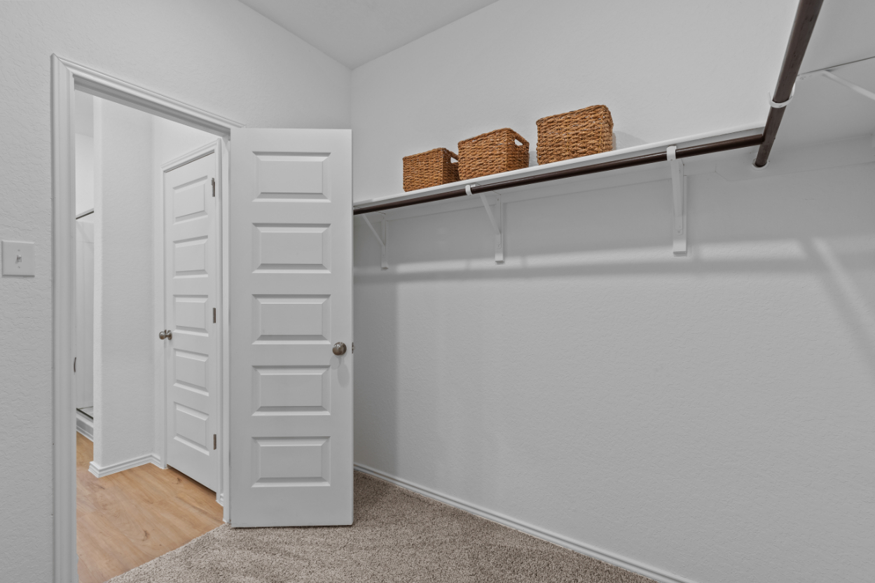 A white shelving unit with baskets on it.