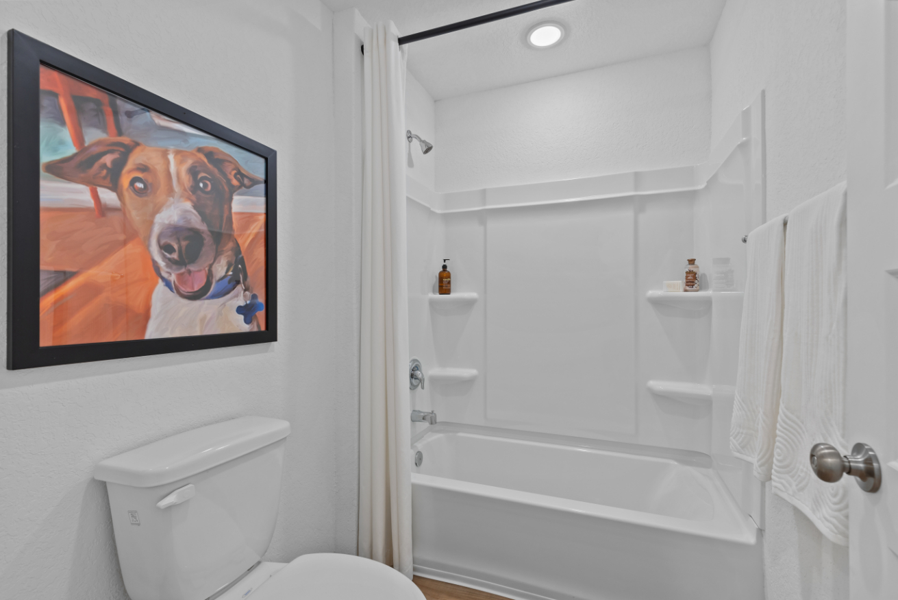 A bathroom with a picture on the wall.