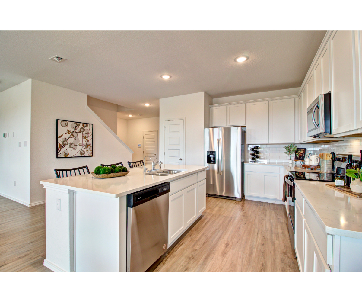 A kitchen with white cabinets.