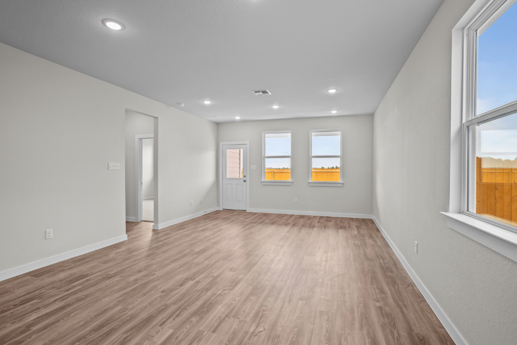A room with a wood floor and windows.