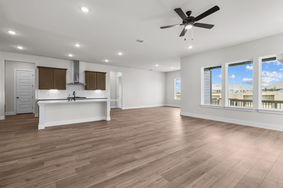 A large kitchen with a wood floor.