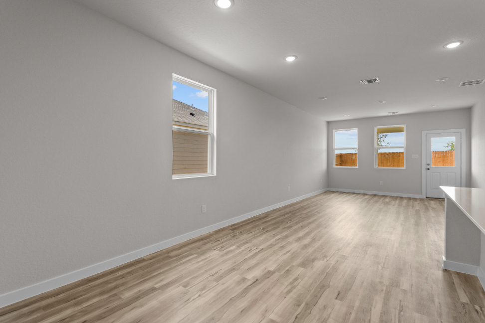 A room with a wood floor and windows.
