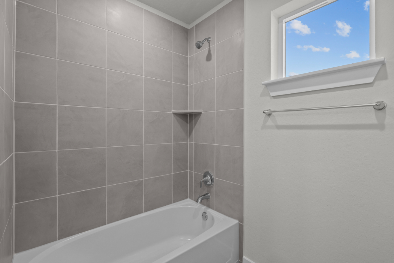 A bathroom with a bathtub and a window.