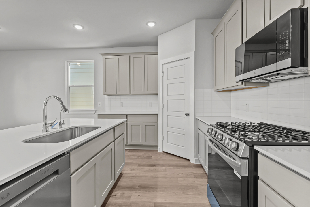 A kitchen with white cabinets.
