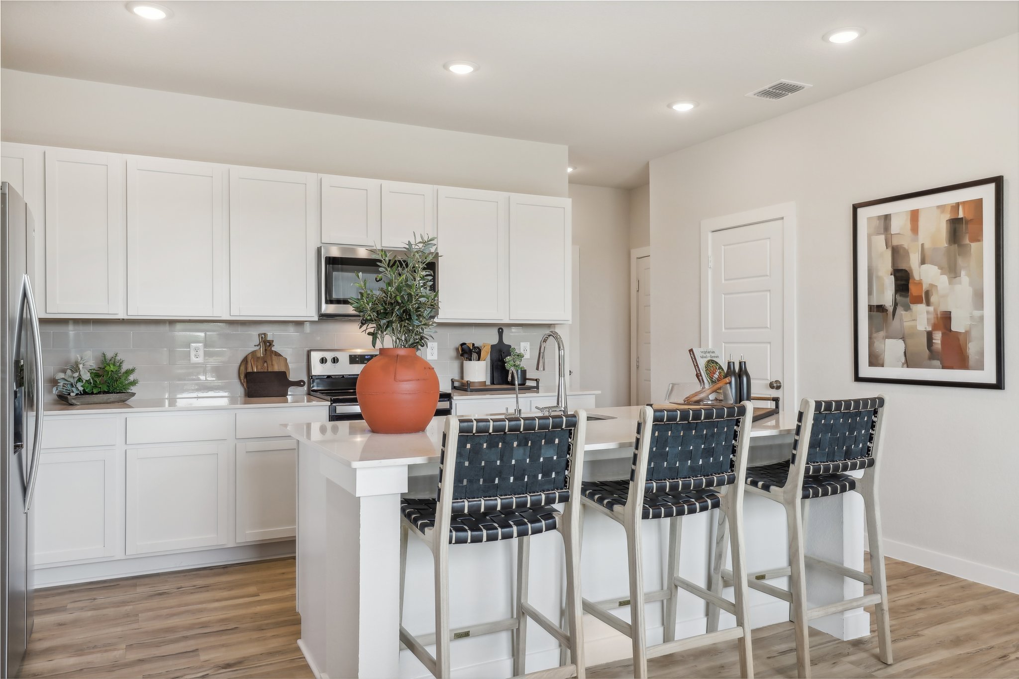 A kitchen with white cabinets.