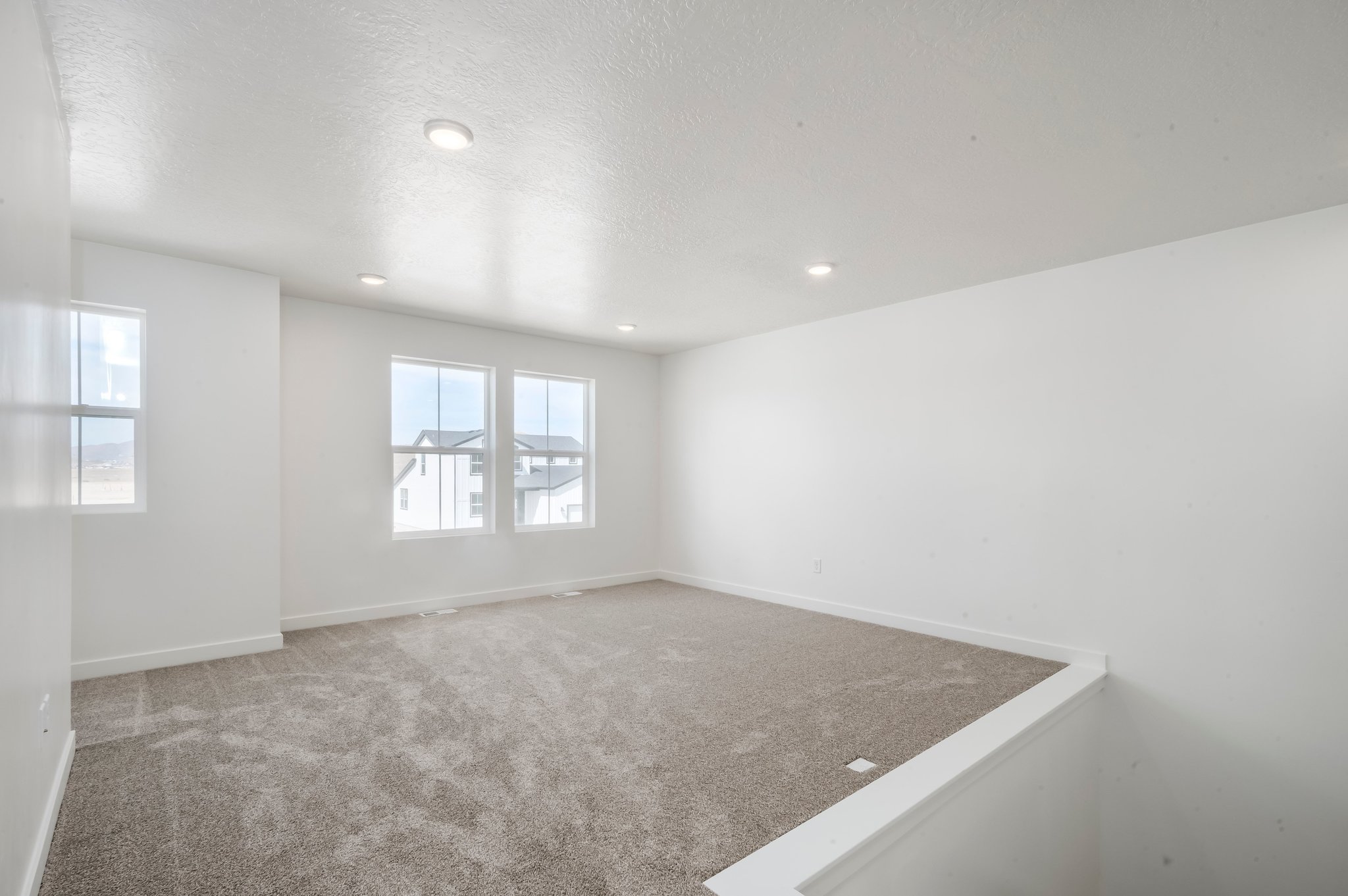 A room with a carpet and windows.