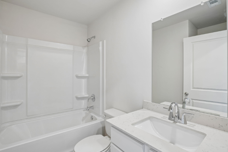 A bathroom with a tub sink and toilet.