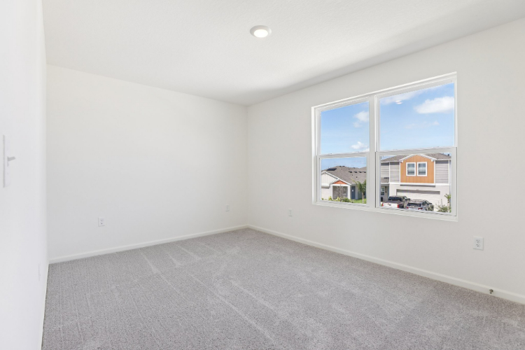 A room with a window and a carpet.