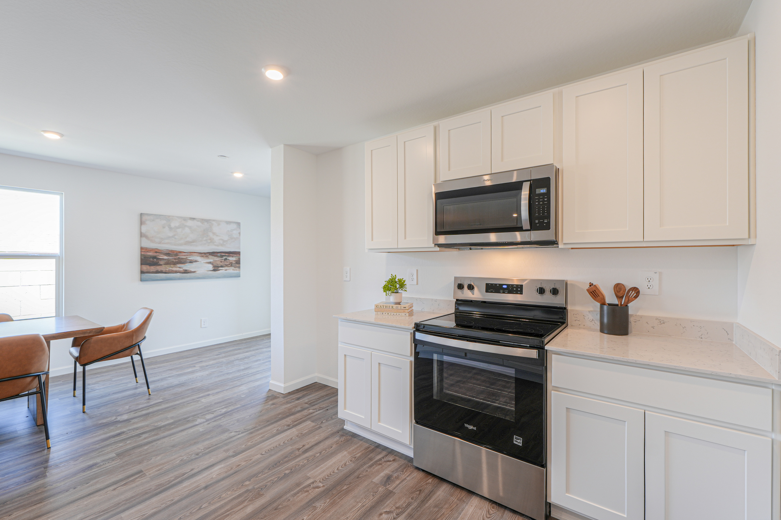 A kitchen with white cabinets.