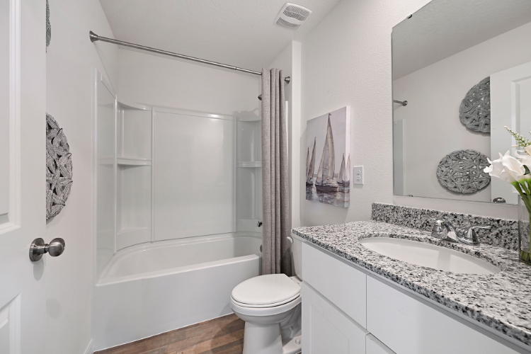 A bathroom with a tub sink and toilet.