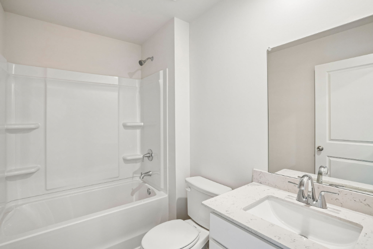 A bathroom with a tub sink and toilet.