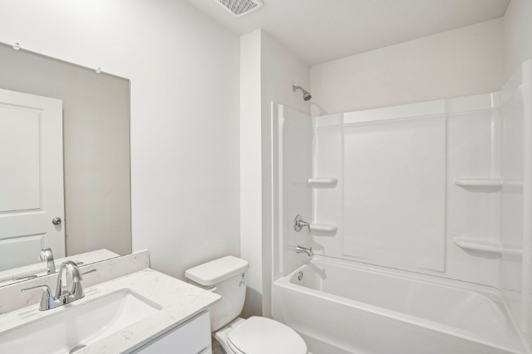 A bathroom with a tub sink and toilet.