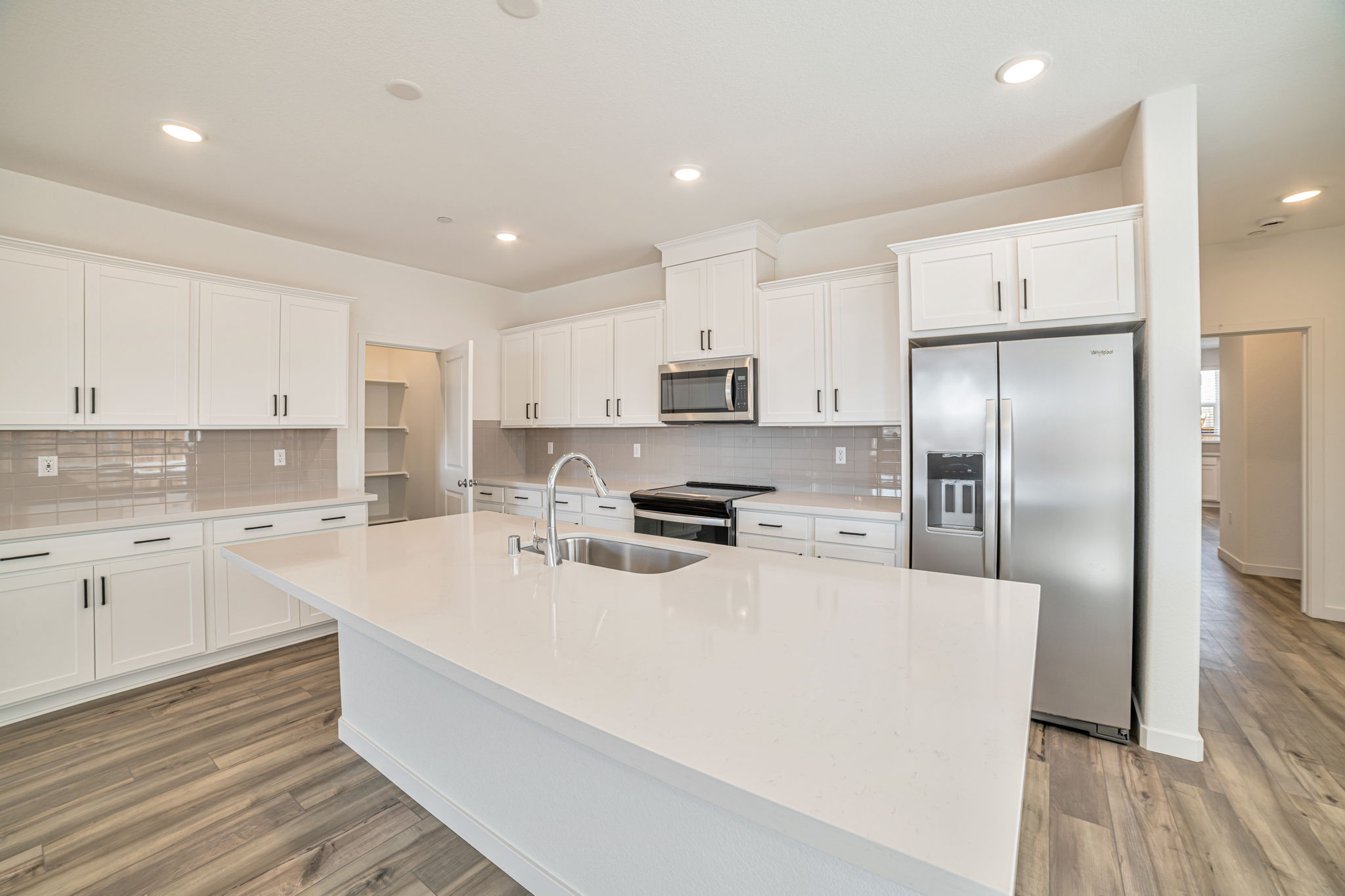 A kitchen with white cabinets.