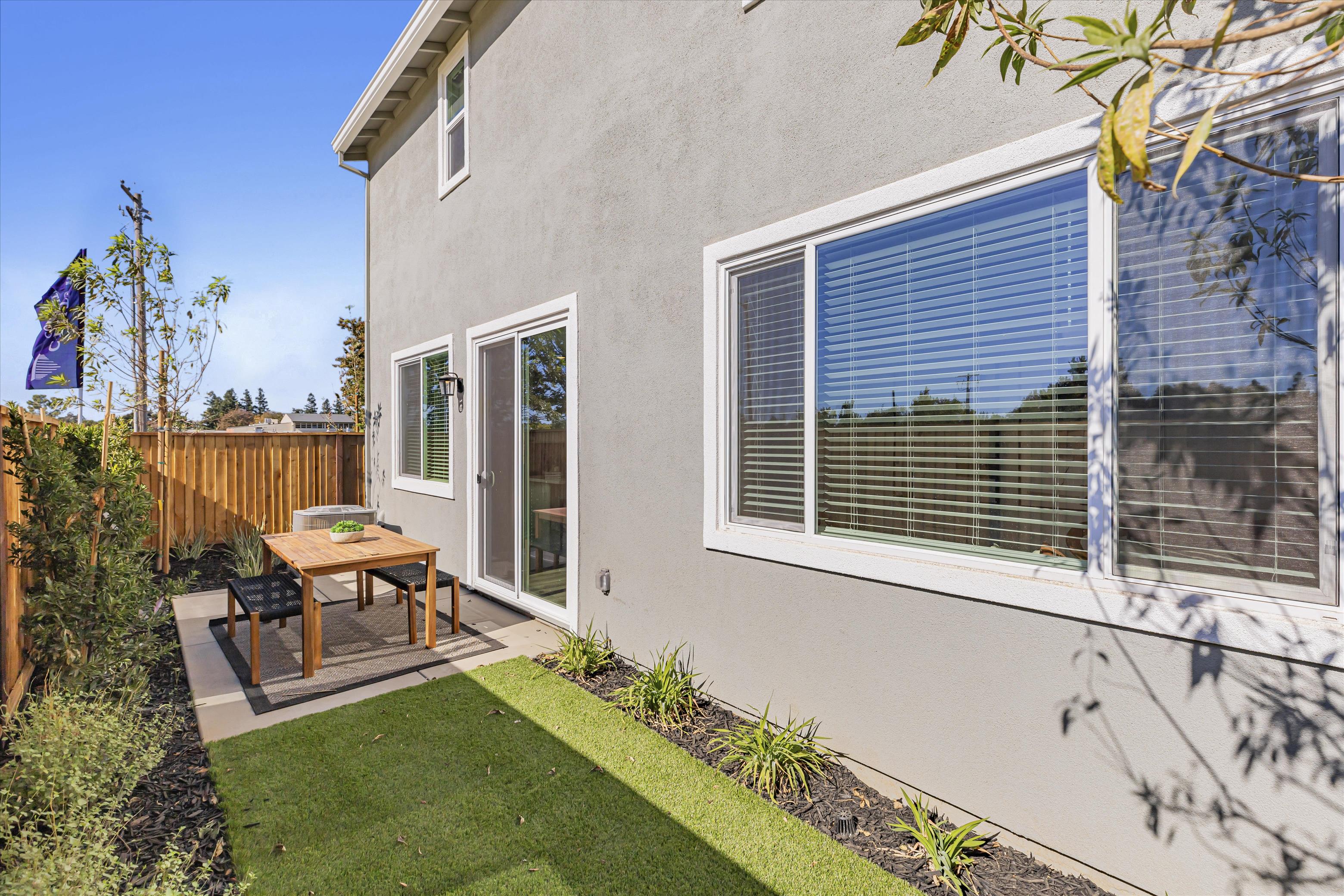 A house with a patio and a table and chairs in the front.